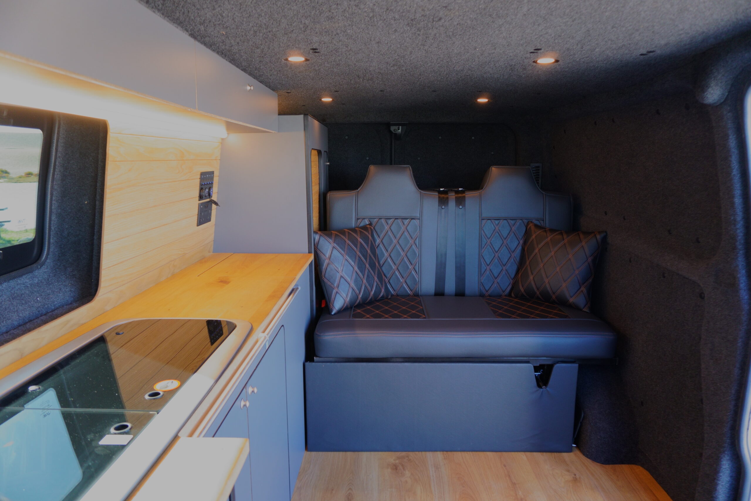 Coastal Weekender campervan interior with kitchenette and bench seating